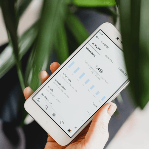 An iPhone checking social media marketing statistics on Instagram.