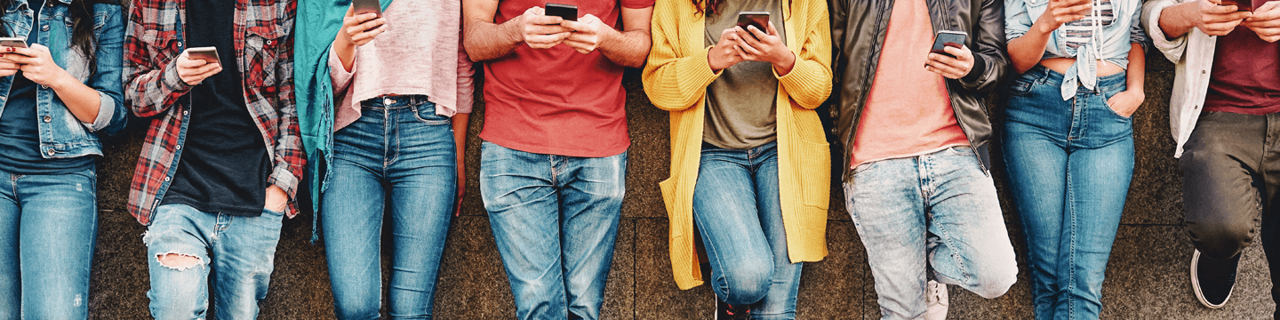 A group of people on their phones, representing the importance of social media marketing to reach customers.